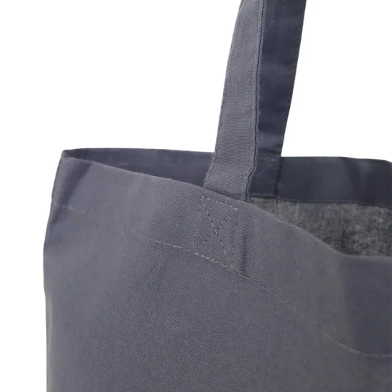 Mörkgrå tygkasse hängande i profil med långa handtag